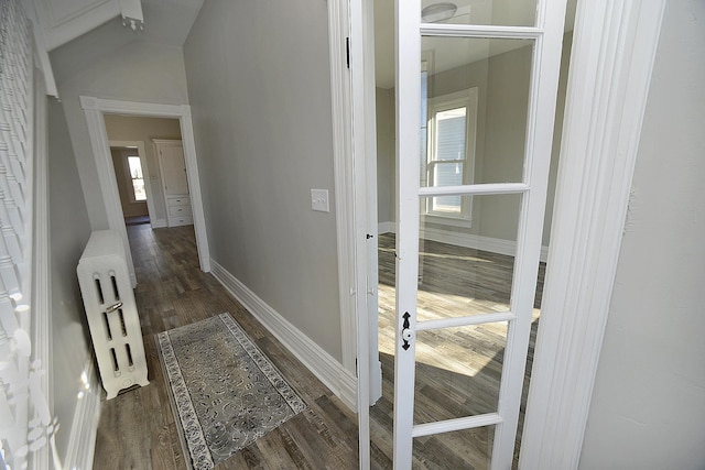 hallway with dark hardwood / wood-style flooring and radiator heating unit