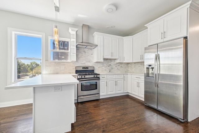 kitchen with dark hardwood / wood-style flooring, stainless steel appliances, wall chimney range hood, pendant lighting, and white cabinetry