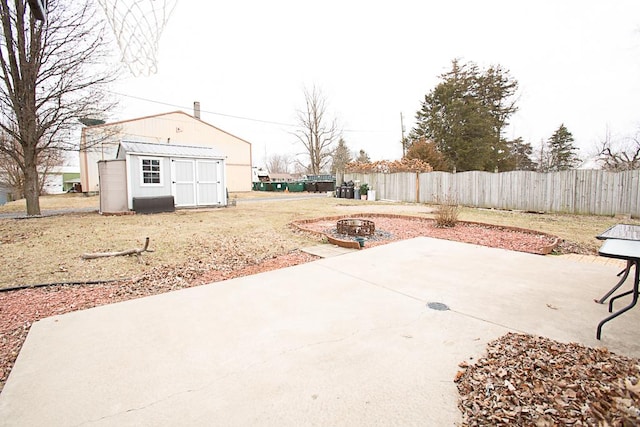 view of patio with a storage shed and a fire pit