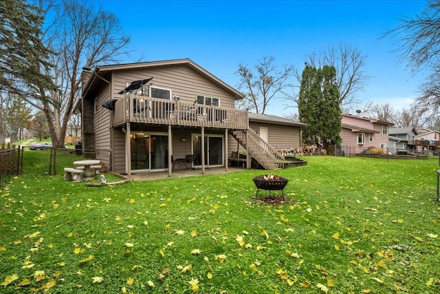 rear view of property featuring a yard, a deck, an outdoor fire pit, and a patio area