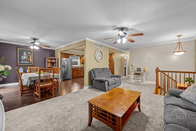 living room with dark colored carpet, ceiling fan, and crown molding