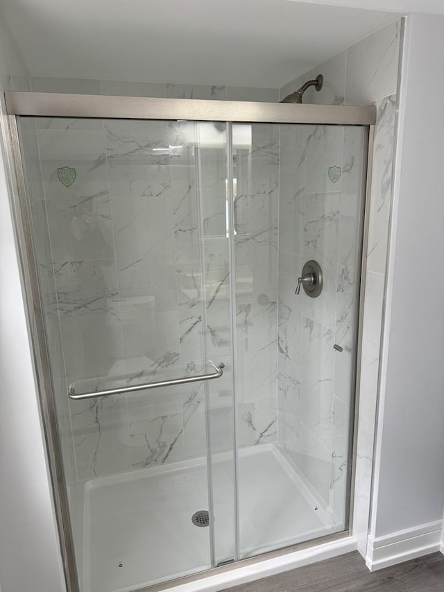 bathroom featuring hardwood / wood-style floors and a shower with door