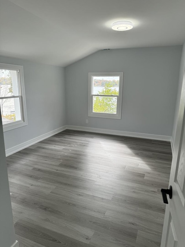 empty room with dark wood-type flooring and a healthy amount of sunlight