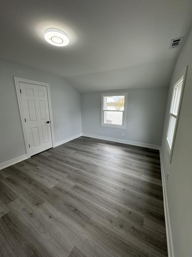 unfurnished room featuring vaulted ceiling and dark wood-type flooring