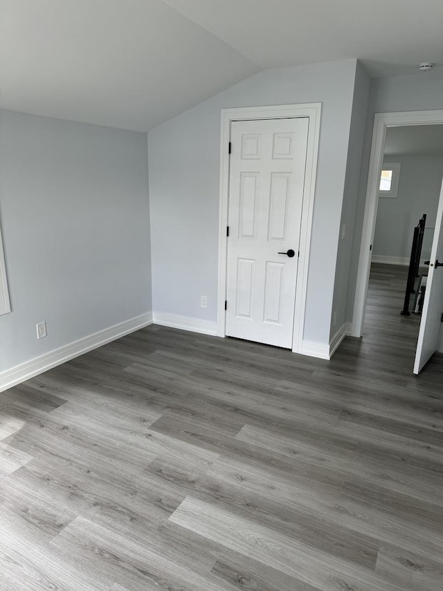 empty room with light hardwood / wood-style floors and lofted ceiling