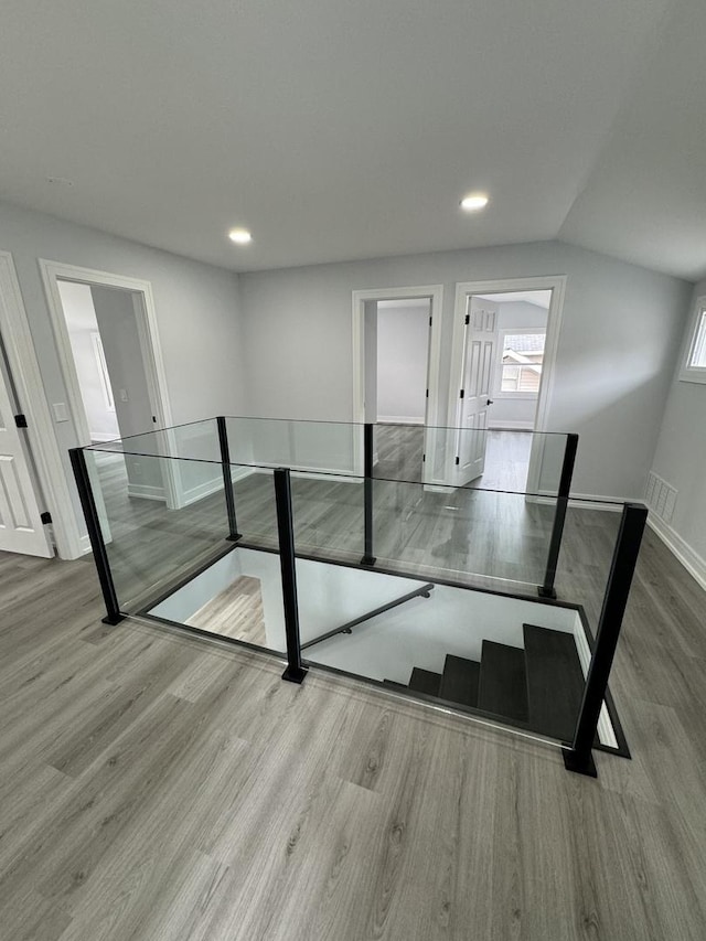 interior space with hardwood / wood-style flooring and vaulted ceiling