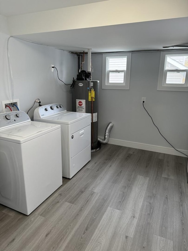 washroom with light wood-type flooring, electric water heater, and separate washer and dryer