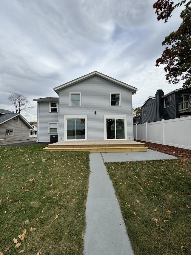 back of property featuring a yard and a wooden deck