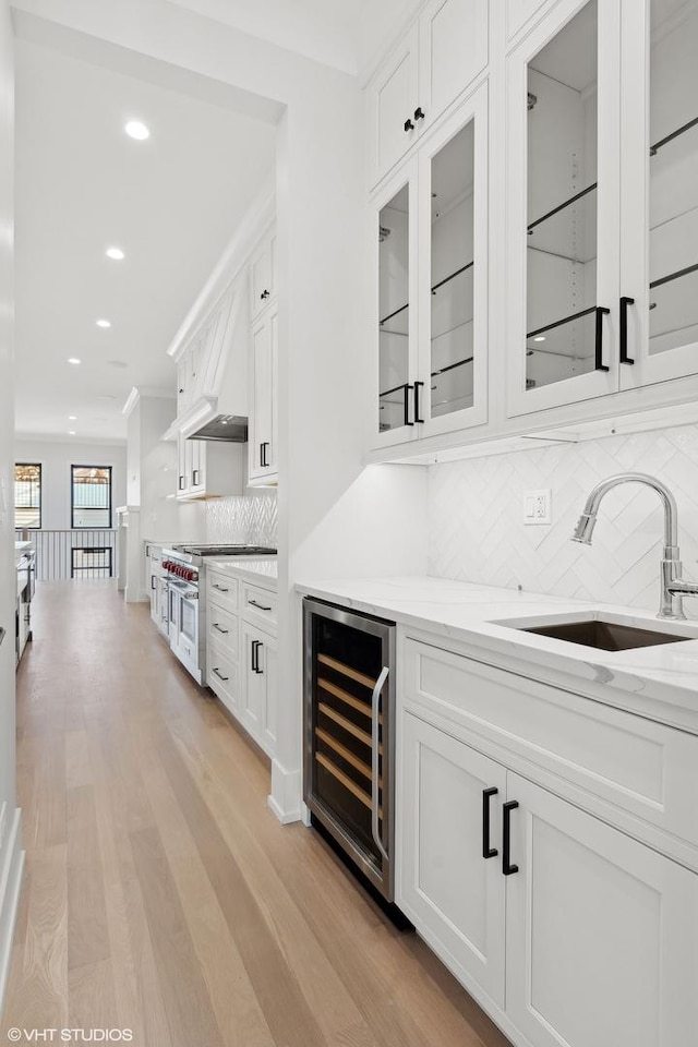 bar with wine cooler, white cabinetry, tasteful backsplash, and premium range hood