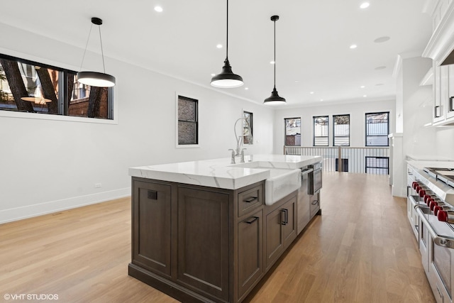 kitchen featuring pendant lighting, light hardwood / wood-style flooring, light stone counters, dark brown cabinetry, and white cabinets