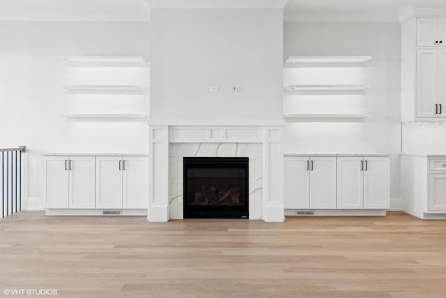 unfurnished living room with a premium fireplace and light wood-type flooring