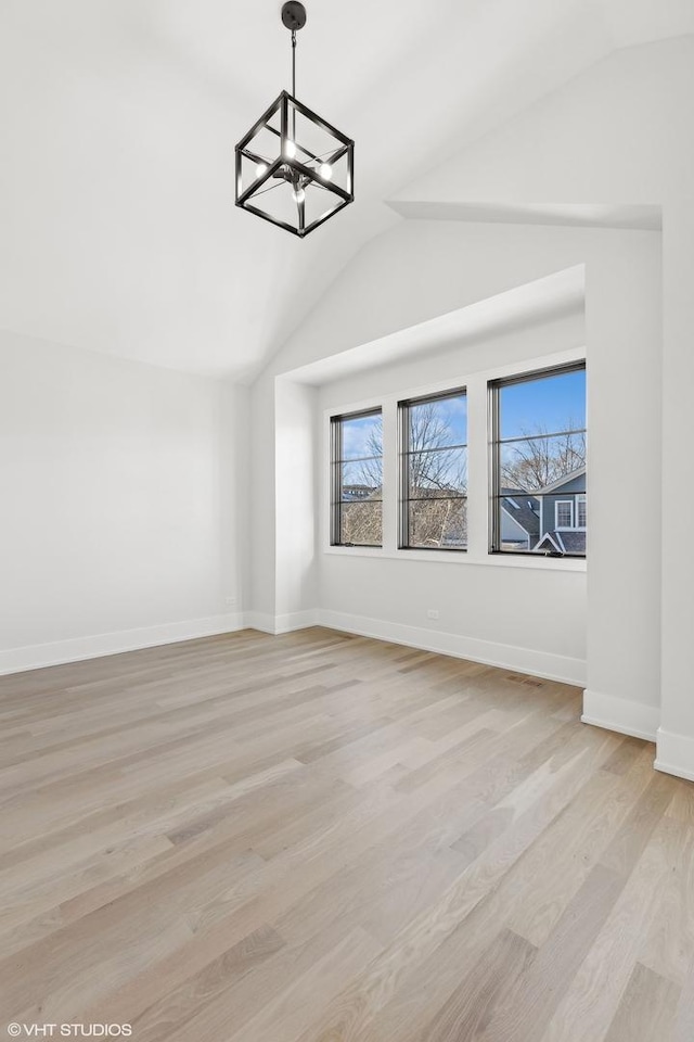 interior space featuring vaulted ceiling, an inviting chandelier, and light wood-type flooring