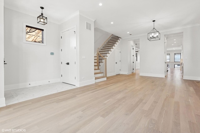 interior space featuring crown molding, light hardwood / wood-style floors, and a chandelier