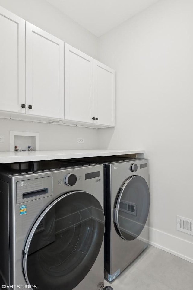 laundry area featuring cabinets and washing machine and clothes dryer