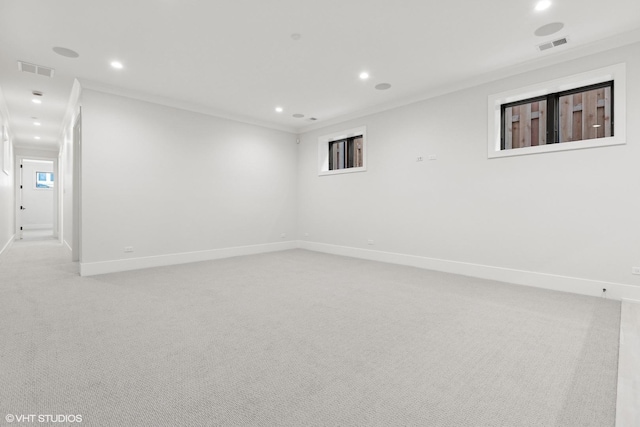 empty room featuring crown molding and light colored carpet