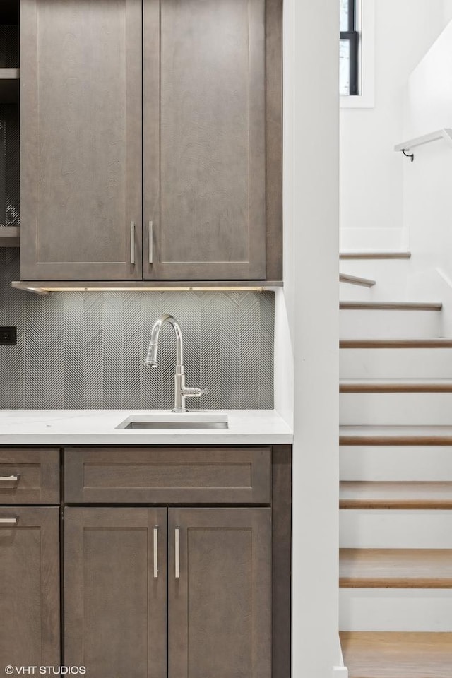 bar featuring sink and dark brown cabinetry