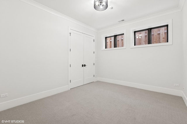 carpeted spare room featuring ornamental molding