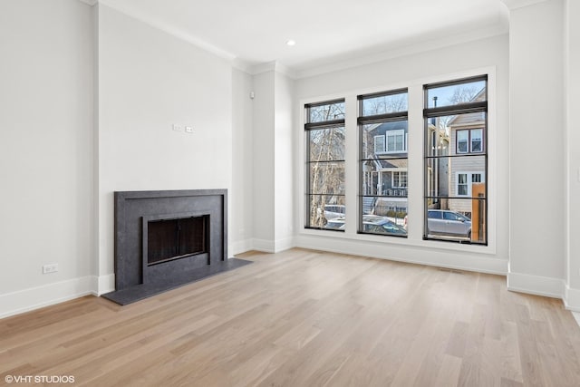 unfurnished living room with crown molding and light hardwood / wood-style flooring