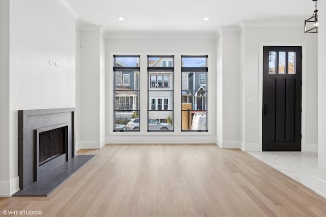 foyer with crown molding and light wood-type flooring