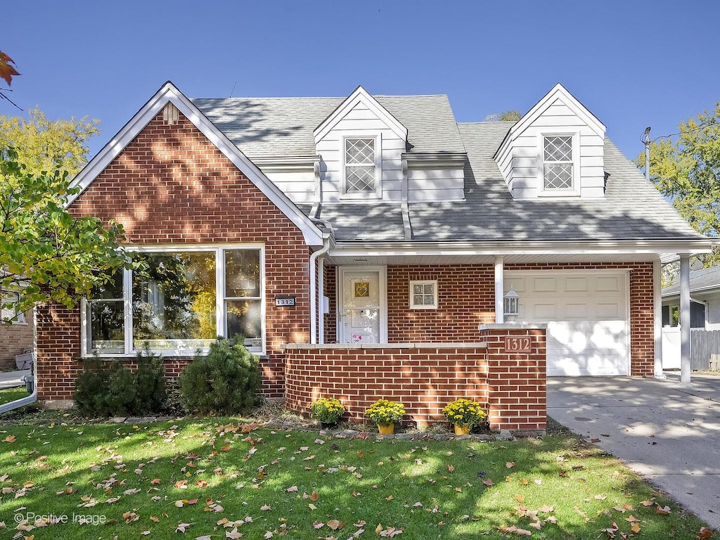 new england style home featuring a front lawn and a garage