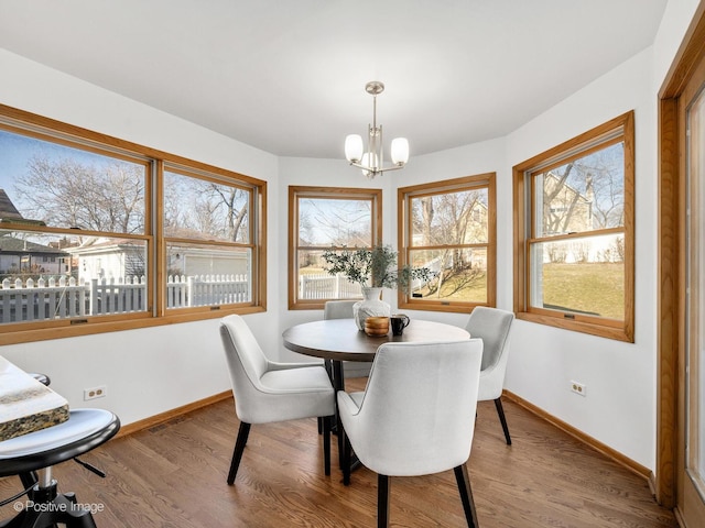 dining room with hardwood / wood-style flooring and an inviting chandelier