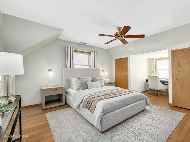 bedroom featuring ceiling fan, lofted ceiling, and light wood-type flooring