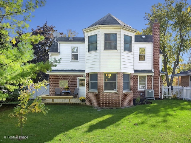 rear view of property with central air condition unit, a yard, and a deck