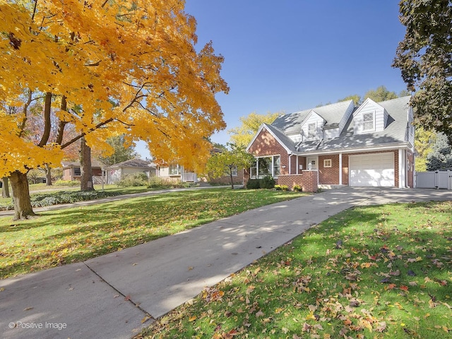 cape cod home with a front yard and a garage