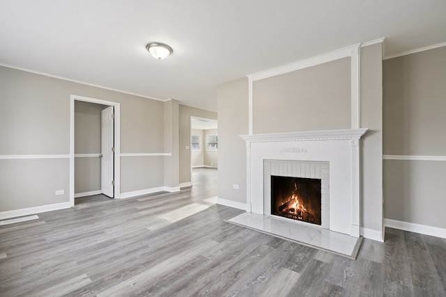 unfurnished living room featuring a fireplace, light hardwood / wood-style floors, and ornamental molding