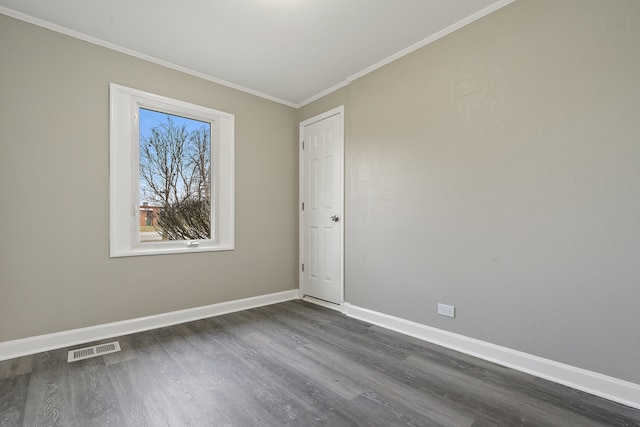 spare room featuring crown molding and dark wood-type flooring