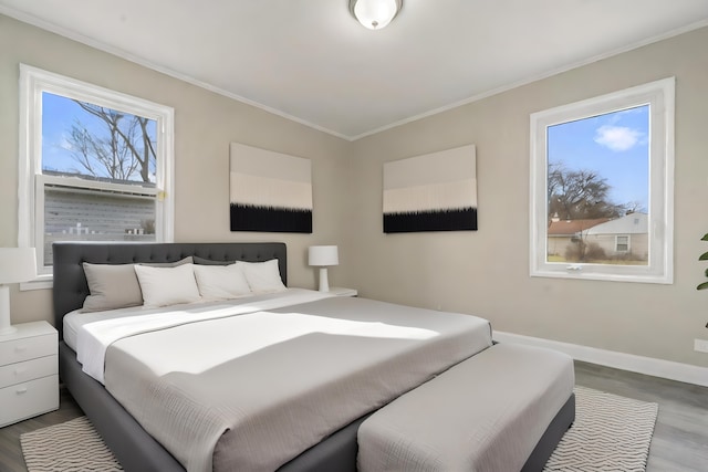 bedroom with multiple windows, hardwood / wood-style floors, and ornamental molding