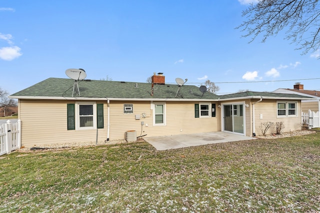 rear view of property with central air condition unit, a patio area, and a lawn