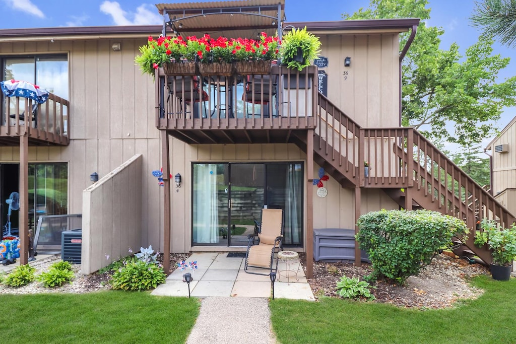 rear view of property featuring a balcony, central air condition unit, and a patio