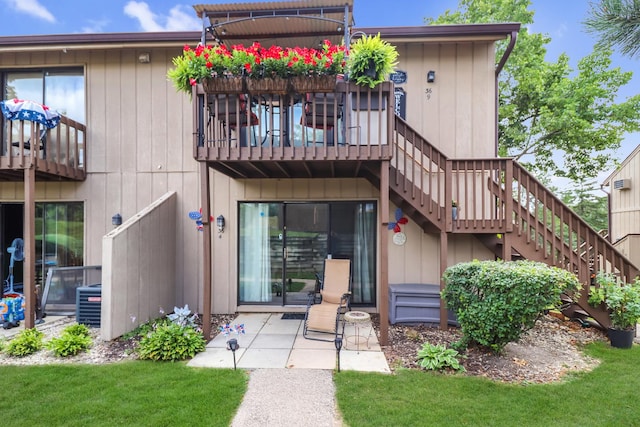 rear view of property featuring a balcony, central air condition unit, and a patio