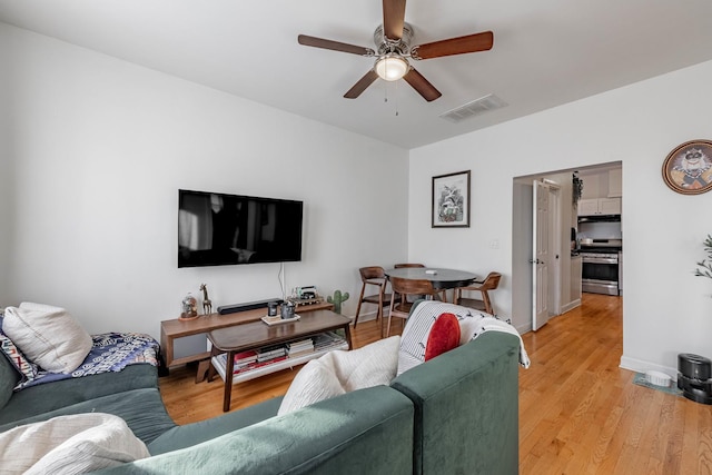 living room featuring ceiling fan and light wood-type flooring