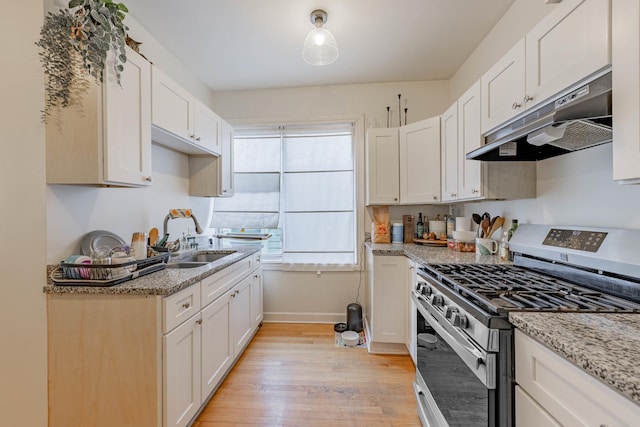 kitchen featuring light stone counters, sink, white cabinets, and stainless steel range with gas stovetop