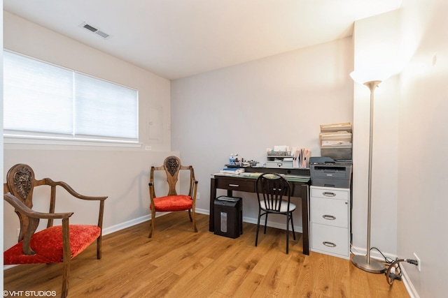 home office with light hardwood / wood-style floors