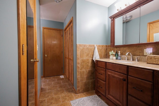 bathroom featuring vanity and tile walls