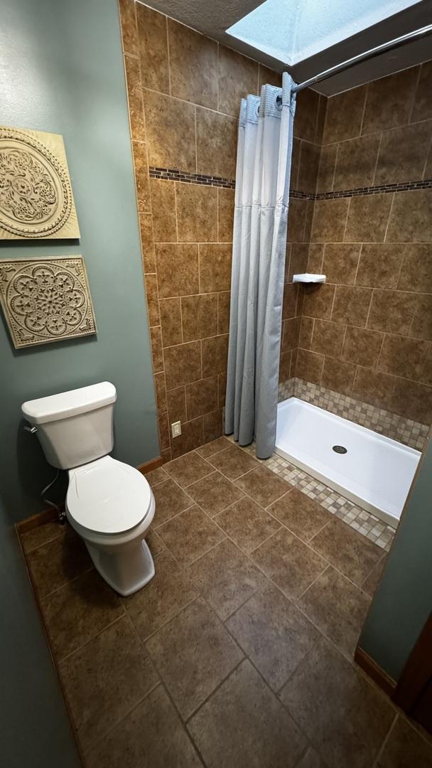 full bath with a stall shower and toilet