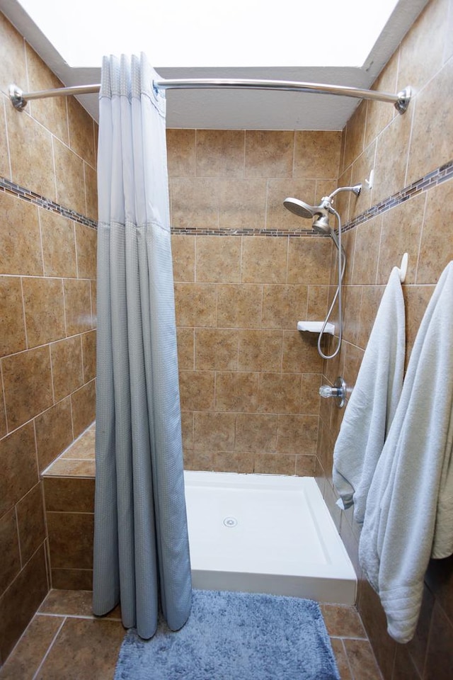 bathroom with a shower with curtain and a skylight