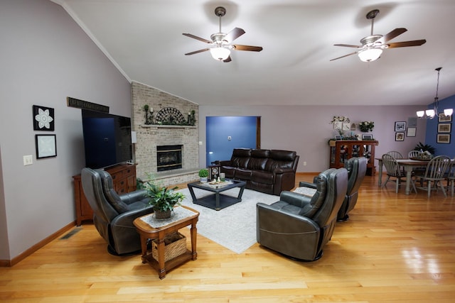 living room with ceiling fan with notable chandelier, light wood-type flooring, and lofted ceiling