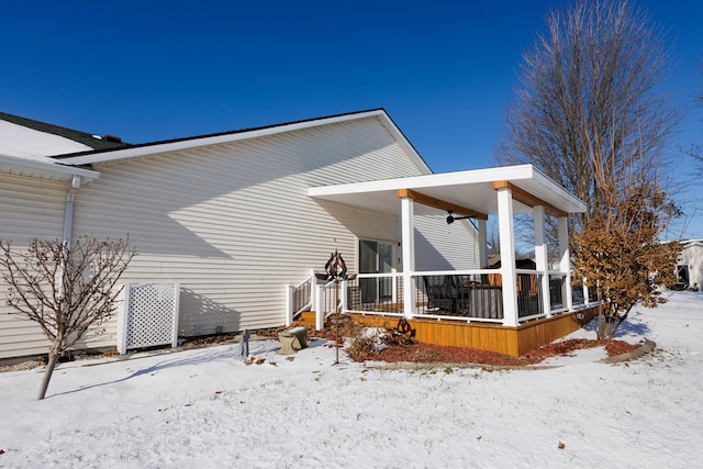 view of snow covered rear of property