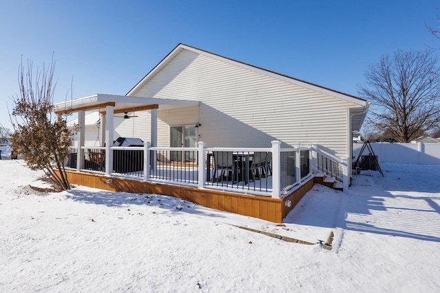 snow covered rear of property featuring ceiling fan