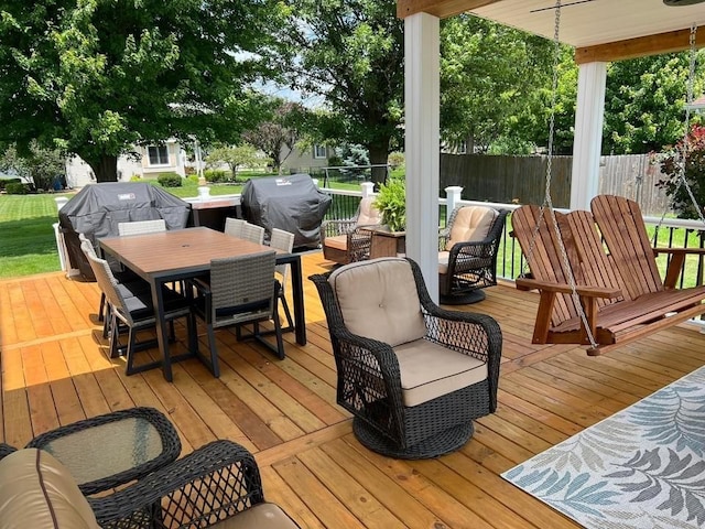 deck with outdoor dining area, a grill, and fence