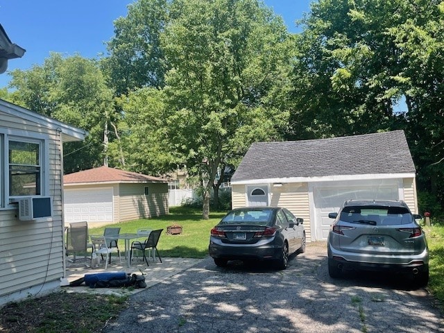 exterior space featuring a garage, a lawn, and cooling unit