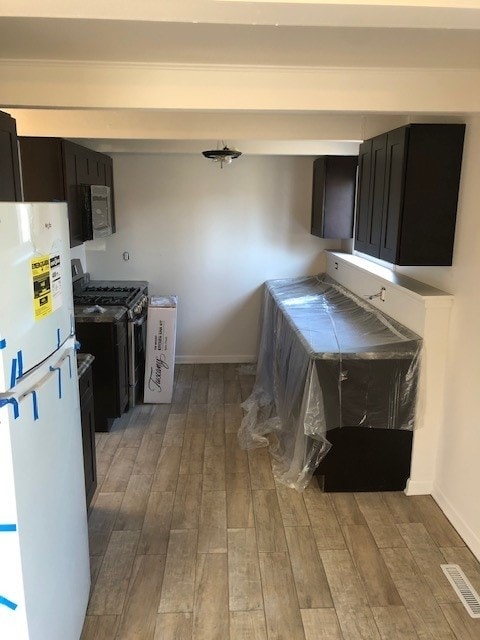 kitchen with light hardwood / wood-style floors, appliances with stainless steel finishes, and tile counters