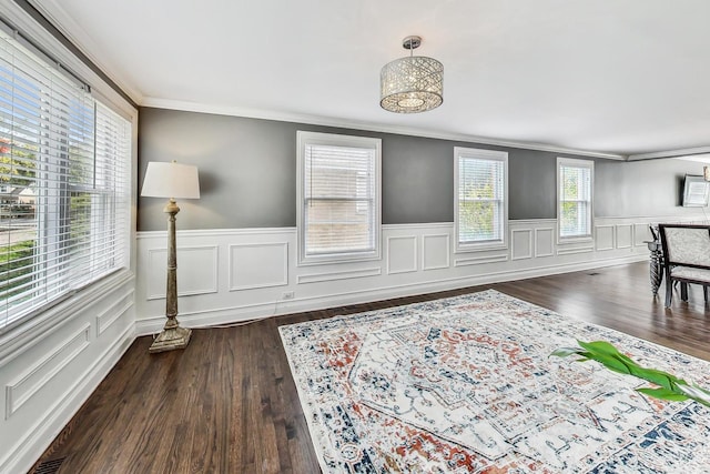 living room featuring plenty of natural light, dark hardwood / wood-style floors, and crown molding