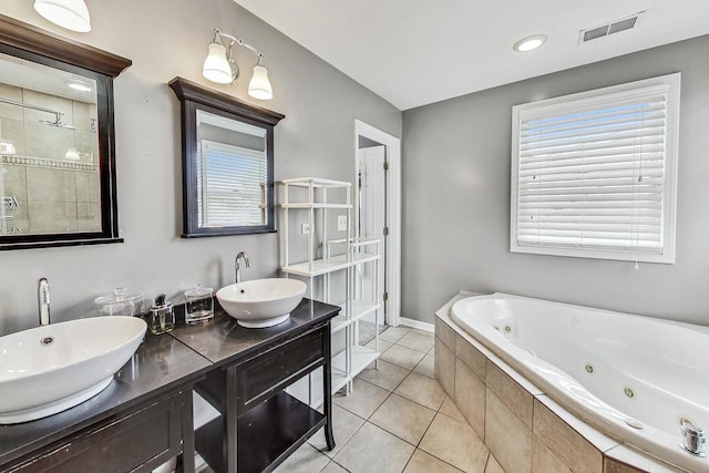 bathroom with vanity, a relaxing tiled tub, and tile patterned floors