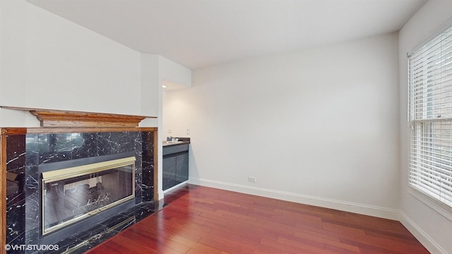 living room featuring a high end fireplace and dark wood-type flooring