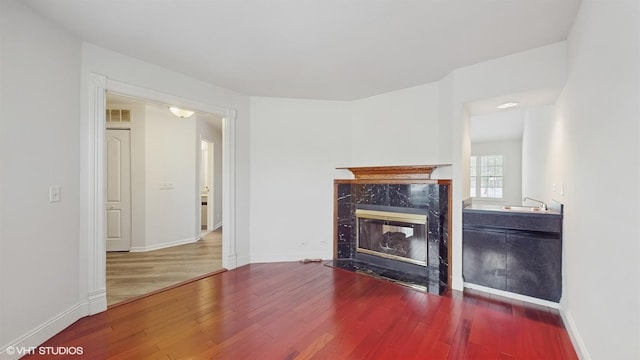 living room featuring hardwood / wood-style floors, sink, and a fireplace